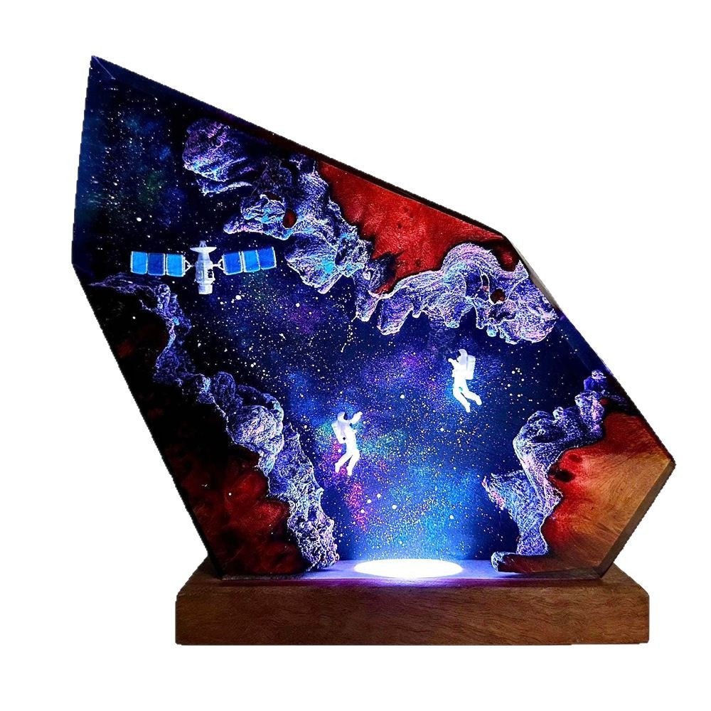 Orbit Lamp — an astronaut and a satellite suspended in a resin nebula on a wood base, lit from below