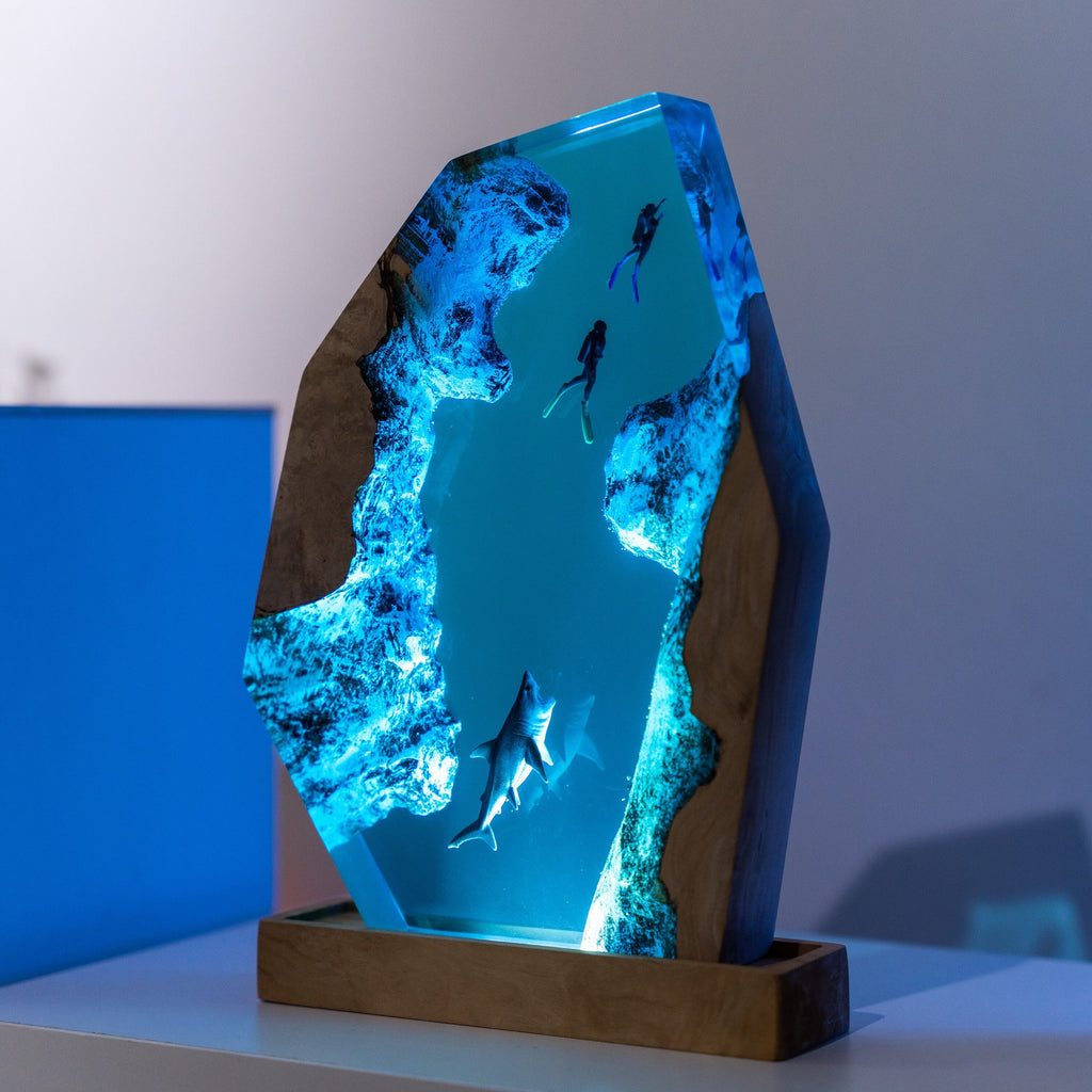 Diver Lamp — two divers and a shark in open blue water, cast in resin between two pieces of wood